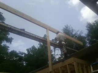 Carpenter setting a ridge beam over a new addition frame — Ice Dam Removal by Roofing Brothers in Waterville